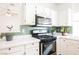 The charming kitchen has stainless steel appliances, white cabinets, and tiled backsplash at 6808 Indian Chief Dr # 204, Las Vegas, NV 89130