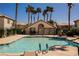 Community pool surrounded by palm trees and lounge chairs for relaxation on a sunny day at 6808 Indian Chief Dr # 204, Las Vegas, NV 89130