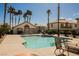 Inviting community pool area with tall palm trees, lounge chairs, and clubhouse in the background at 6808 Indian Chief Dr # 204, Las Vegas, NV 89130