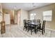 Cozy dining room with wood-look tile, a dark table set, and an open layout flowing into other living spaces at 6897 Linda Creek Ct, Las Vegas, NV 89178