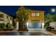 Charming two-story home at night with a well-manicured front yard, stone accents, and a two-car garage at 6897 Linda Creek Ct, Las Vegas, NV 89178