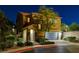 Inviting two-story home at dusk featuring a manicured lawn, stone details, and a spacious two-car garage at 6897 Linda Creek Ct, Las Vegas, NV 89178