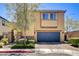 Inviting two-story home featuring a blue garage door, stone accents, and well-manicured landscaping at 6897 Linda Creek Ct, Las Vegas, NV 89178