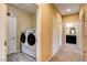 Hallway featuring a laundry room with front load machines and a bathroom at 6897 Linda Creek Ct, Las Vegas, NV 89178
