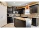 Modern kitchen boasting dark wood cabinets, granite countertops, a central island, and stainless appliances at 6897 Linda Creek Ct, Las Vegas, NV 89178