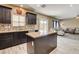 Bright kitchen features dark cabinets, granite countertops, and a mosaic tile backsplash at 6897 Linda Creek Ct, Las Vegas, NV 89178