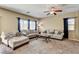 Comfortable living room with plush seating, large windows, and a ceiling fan for added comfort at 6897 Linda Creek Ct, Las Vegas, NV 89178