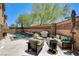 Outdoor living space complete with a modern pool, patio furniture, and a built-in grill at 6897 Linda Creek Ct, Las Vegas, NV 89178