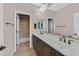 Bathroom boasts dual sinks with dark wood cabinets and tile floors at 7033 Twin Forks Peak St, Las Vegas, NV 89166