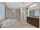 Elegant bathroom featuring a soaking tub, frameless glass shower, and vanity with dual sinks at 7033 Twin Forks Peak St, Las Vegas, NV 89166
