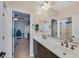 Bathroom featuring double sinks with bronze faucets and an entry to the bedroom at 7033 Twin Forks Peak St, Las Vegas, NV 89166