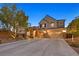 Charming two-story home featuring a well-maintained front yard, a three-car garage, and mature trees at 7033 Twin Forks Peak St, Las Vegas, NV 89166