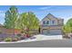 Charming two-story home featuring a three-car garage and a beautifully landscaped front yard with mature trees at 7033 Twin Forks Peak St, Las Vegas, NV 89166