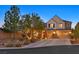Inviting two-story home with a well-maintained front yard, a three-car garage, and mature trees at 7033 Twin Forks Peak St, Las Vegas, NV 89166
