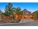 Charming two-story home with a three-car garage, a well-manicured lawn, and mature trees at 7033 Twin Forks Peak St, Las Vegas, NV 89166