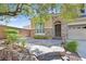 Inviting stone accented entrance featuring mature landscaping and a stone walkway at 7033 Twin Forks Peak St, Las Vegas, NV 89166