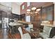 Gourmet kitchen with dark cabinetry, granite countertops, and a cozy dining area at 7033 Twin Forks Peak St, Las Vegas, NV 89166