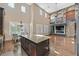 Open-concept kitchen featuring a large island, stone fireplace, stainless steel appliances, and breakfast nook at 7033 Twin Forks Peak St, Las Vegas, NV 89166