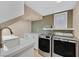 Well-equipped laundry room with modern washer, dryer, and built-in cabinets provides ample storage and convenience at 7033 Twin Forks Peak St, Las Vegas, NV 89166