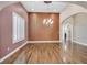 Spacious formal living room with hardwood floors, an elegant chandelier, and large windows with plantation shutters at 7033 Twin Forks Peak St, Las Vegas, NV 89166