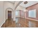 Spacious formal living room with hardwood floors, an elegant chandelier, and large windows with plantation shutters at 7033 Twin Forks Peak St, Las Vegas, NV 89166