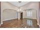 Spacious formal living room with hardwood floors, an elegant chandelier, and large windows with plantation shutters at 7033 Twin Forks Peak St, Las Vegas, NV 89166