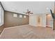 Large carpeted bedroom with a ceiling fan, plantation shutters, and access to the bathroom at 7033 Twin Forks Peak St, Las Vegas, NV 89166