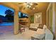 Cozy covered patio with comfortable seating, ceiling fan, and view of the pool and tiki bar at 7033 Twin Forks Peak St, Las Vegas, NV 89166