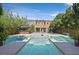 Beautiful backyard with a large swimming pool, a tiki bar, lush landscaping and a seating area at 7033 Twin Forks Peak St, Las Vegas, NV 89166