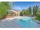 Inviting backyard pool with a swim-up bar, palm trees and a waterfall feature, ideal for relaxing or entertaining guests at 7033 Twin Forks Peak St, Las Vegas, NV 89166
