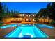 Backyard oasis with a large pool, in-pool lighting, outdoor bar, and well-manicured greenery at 7033 Twin Forks Peak St, Las Vegas, NV 89166