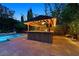 Inviting poolside bar with a thatched roof, perfect for outdoor entertaining at twilight at 7033 Twin Forks Peak St, Las Vegas, NV 89166