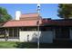 Back exterior with brick details, covered patio, tiled roof, and green grass at 761 Bourbon St # 5, Pahrump, NV 89048