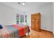 Bedroom featuring hardwood floors, a large wooden wardrobe, and natural light at 7909 Canoe Ln, Las Vegas, NV 89145