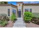 Inviting front entrance with a decorative door, manicured shrubs, and tiled stairs at 7909 Canoe Ln, Las Vegas, NV 89145