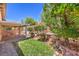 Lush backyard features green grass, brick retaining wall, patio, and foliage at 7998 Base Camp Ave, Las Vegas, NV 89178