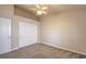This bedroom features neutral carpet, a ceiling fan, and white closet doors at 7998 Base Camp Ave, Las Vegas, NV 89178