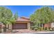 Inviting single-Gathering home showcasing a two-car garage, paver driveway, and mature trees for curb appeal at 7998 Base Camp Ave, Las Vegas, NV 89178