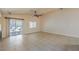 Bright and airy living room with tile flooring, ceiling fan, and sliding glass door to the backyard at 7998 Base Camp Ave, Las Vegas, NV 89178
