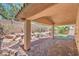 Covered patio has brick floor, natural landscaping, and brick retaining wall at 7998 Base Camp Ave, Las Vegas, NV 89178