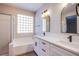 Modern bathroom with double vanity, quartz countertop, and shower over tub with glass enclosure at 8026 Sunset Creek St, Las Vegas, NV 89113