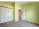 Bright bedroom featuring carpeted floors, light green walls, and a sliding door closet, offering comfort and style at 812 Bitterroot St, Henderson, NV 89002