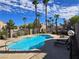 Beautiful blue swimming pool area with lounge chairs and palm trees, perfect for relaxing at 8455 W Sahara Ave # 258, Las Vegas, NV 89117
