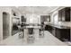 A spacious kitchen featuring dark cabinets, stainless steel appliances, a large island, and marble floors at 8543 Alpine Vineyards Ct, Las Vegas, NV 89139