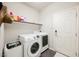 Bright laundry room with white washer and dryer, floating shelves, and ample space at 8543 Alpine Vineyards Ct, Las Vegas, NV 89139