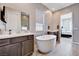 Relaxing bathroom with a soaking tub between two vanities and access to the main bedroom at 8934 Windgate Ranch St, Las Vegas, NV 89166