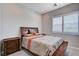 Cozy bedroom with a comfortable bed, wood furniture and bright window light at 8934 Windgate Ranch St, Las Vegas, NV 89166