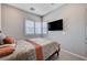 Well-lit bedroom featuring a mounted TV and window with plantation shutters at 8934 Windgate Ranch St, Las Vegas, NV 89166