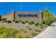 A decorative stone sign with 'Montrose' displayed in blue lettering, surrounded by lush landscaping and greenery at 8934 Windgate Ranch St, Las Vegas, NV 89166