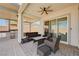 Relaxing covered patio featuring stylish seating, a ceiling fan, and an outdoor kitchen area at 8934 Windgate Ranch St, Las Vegas, NV 89166